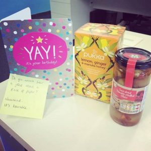 An image showing a jar of olives, harbal tea and a birthday card for Sarah's birthday