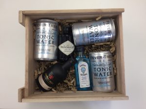 An image showing a wooden box filled with a mini gin set