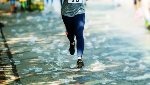 Runner running through road covered in plastic cups